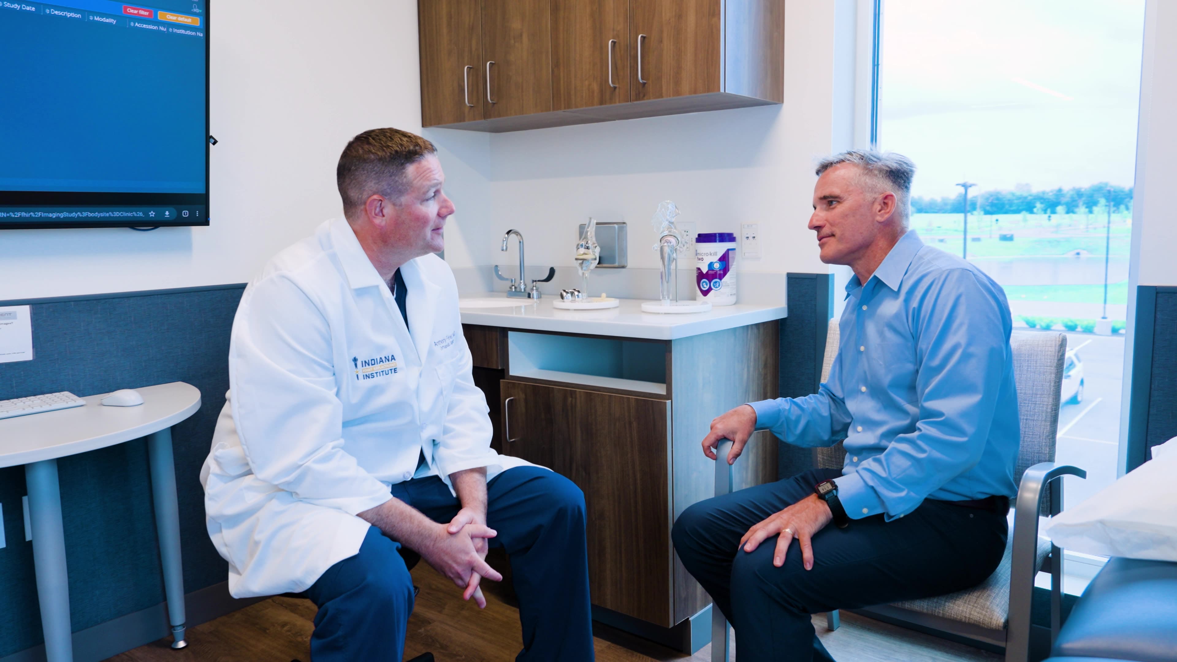 Indiana Orthopedic Institute provider speaking with a patient in an exam room